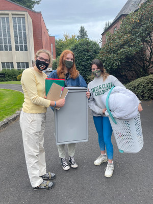 Three students hold free items they found at the L&C Reuse Room.