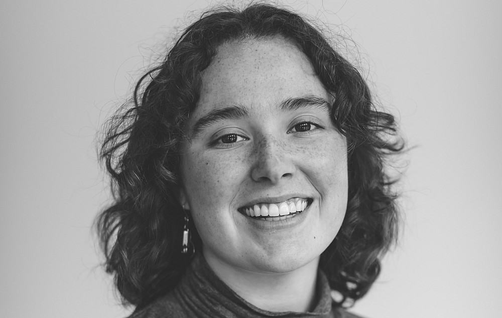 A black and white photo of McKenna, smiling at the camera.