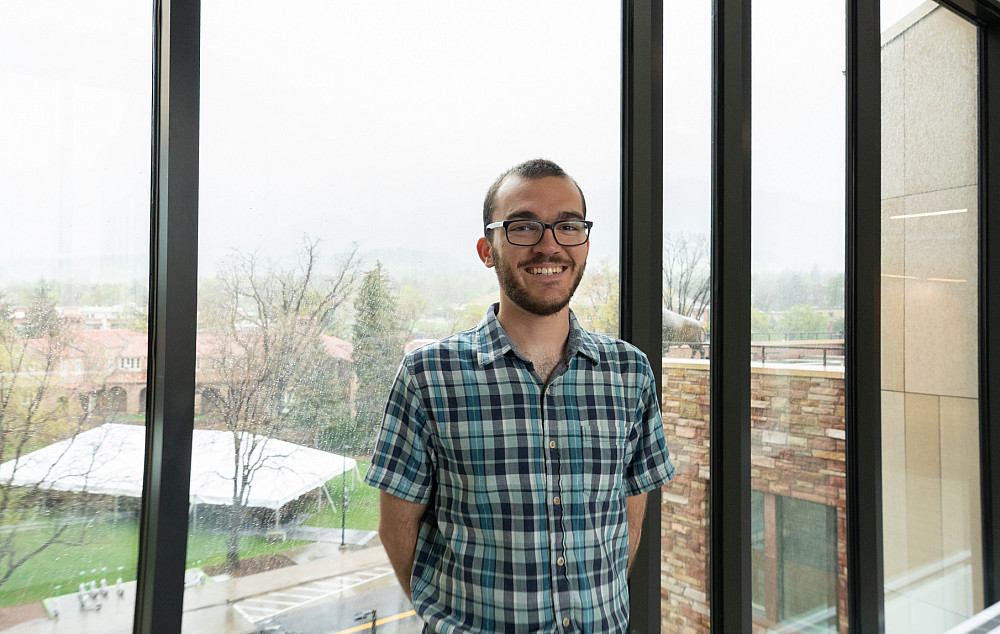 Drew smiling at the camera, wearing a short sleeve checkered shirt.