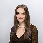 Marta smiling at the camera. She is wearing a black top.