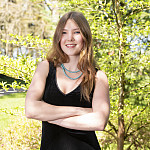 Cadyn posing outside. She is wearing a black tank-top dress.