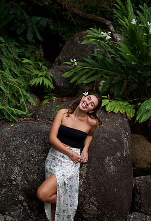 Sophia smiling outside, wearing a black top and silver skirt.