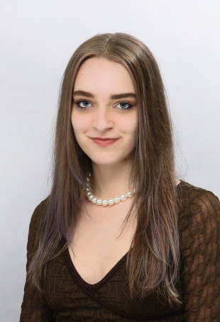 Marta smiling at the camera. She is wearing a black top.