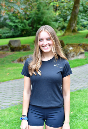 Arielle smiling outside. She is wearing a black tshirt.