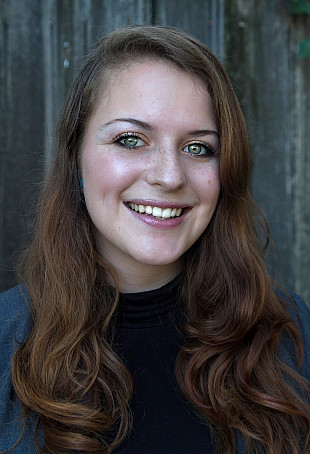 Hanna smiling at the camera wearing a navy blue top and a bright blue cardigan.
