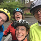 Smiling bike posse members wearing bike helmets.