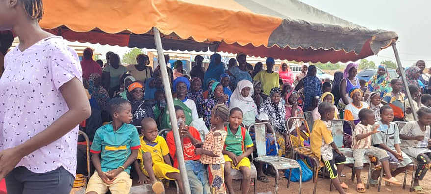 Opening ceremony of the screening campaign with attendees seated under a tent.