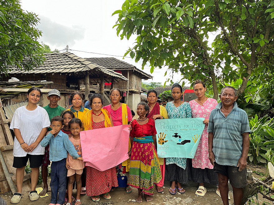 A family of twelve in front of their newly built communal tap.