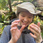 Person smiling at a banana slug on their finger