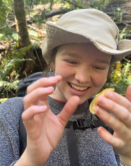 Person smiling at a banana slug on their finger
