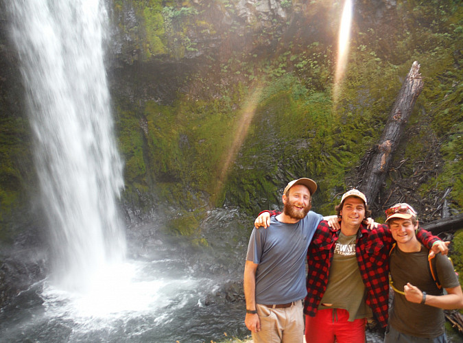 Image shows: Three people standing in front of a waterfall.