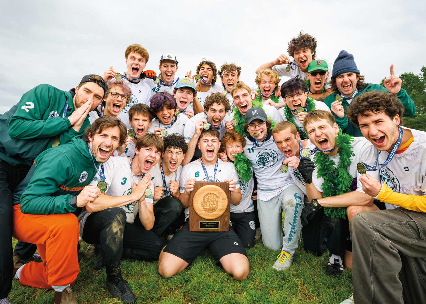 The image shows a large group of a sports team celebrating a victory. They are wearing matching jerseys and medals.
