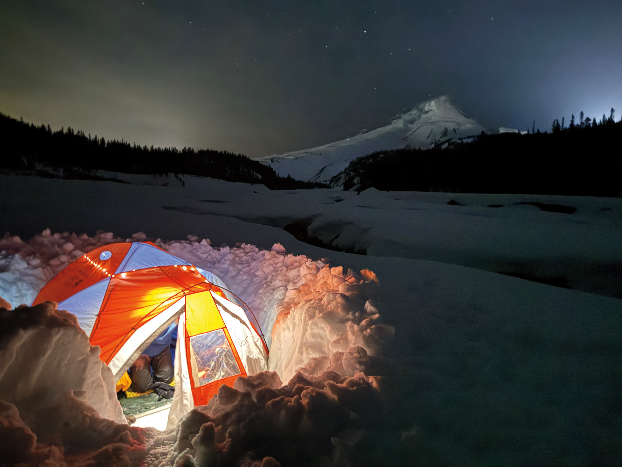STARRY NIGHT On a wintry College Outdoors trip, students learn the practical skills of snow camping--hauling gear sleds, digging w...