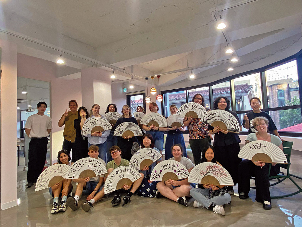 Students proudly display fans they hand-painted at a workshop in Seoul.