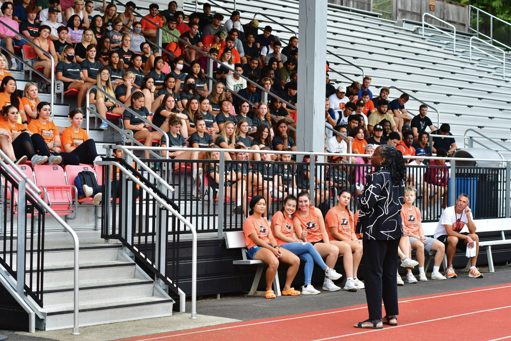 President Robin Holmes-Sullivan speaks in front of a stadium crowd