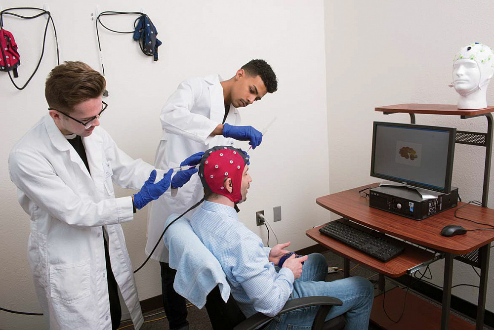 Yuriy Popovich BA '20 (left) and Justice Jarrett BA '20 study cognitive responses to food-related cues with Todd Watson (seated), associa...