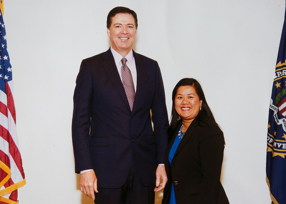 Chanpone Sinlapasai receives the 2014 FBI Director's Community Leadership Award from FBI Director James Comey.