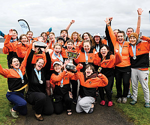 Women's rowing celebrates after winning their first NWC Title in program history.