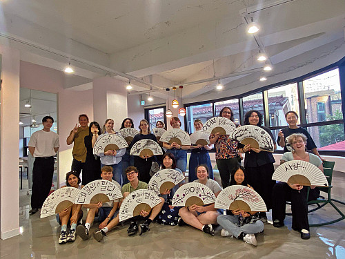 Students proudly display fans they hand-painted at a workshop in Seoul.