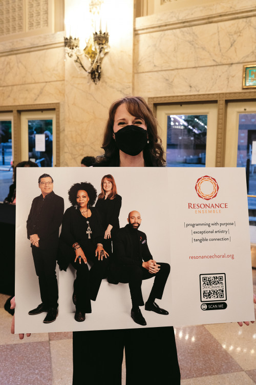 Kathy FitzGibbon, artistic director of the Resonance Ensemble, proudly displays the group's Requiem poster.