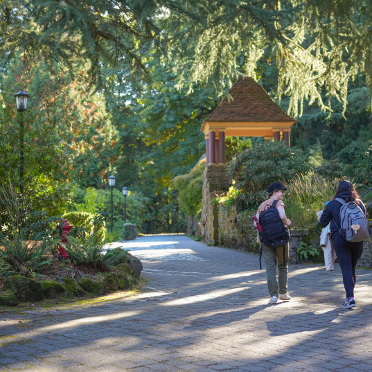 Students walking near gazebos on campus.