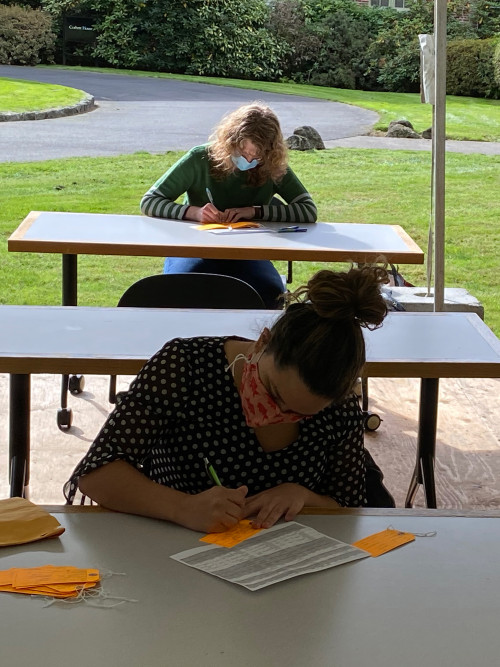 Mary Andrus (background) and Olivia Siulagi filling out toe tags for Hostile Terrain 94 event.