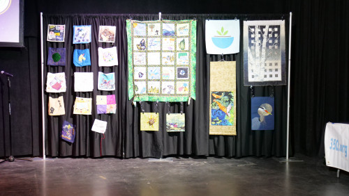 Art for Social Change quilt squares and quilts by the Westside Quilters Guild set up in the theatre.