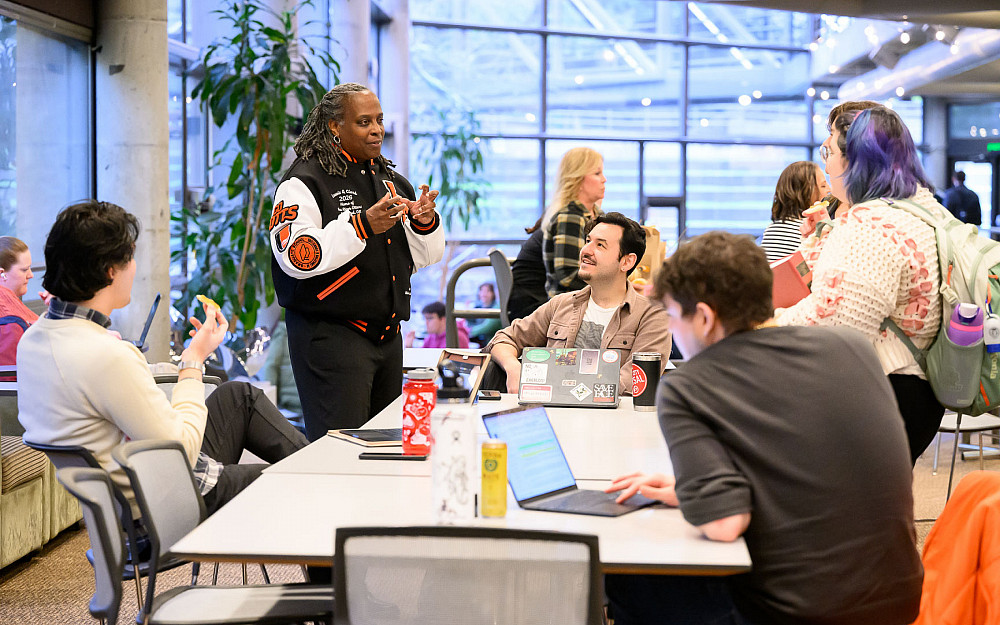 President Robin Holmes-Sullivan speaking with students in Legal Research Center (LRC), wearing her custom L&C River Otters letterman ...