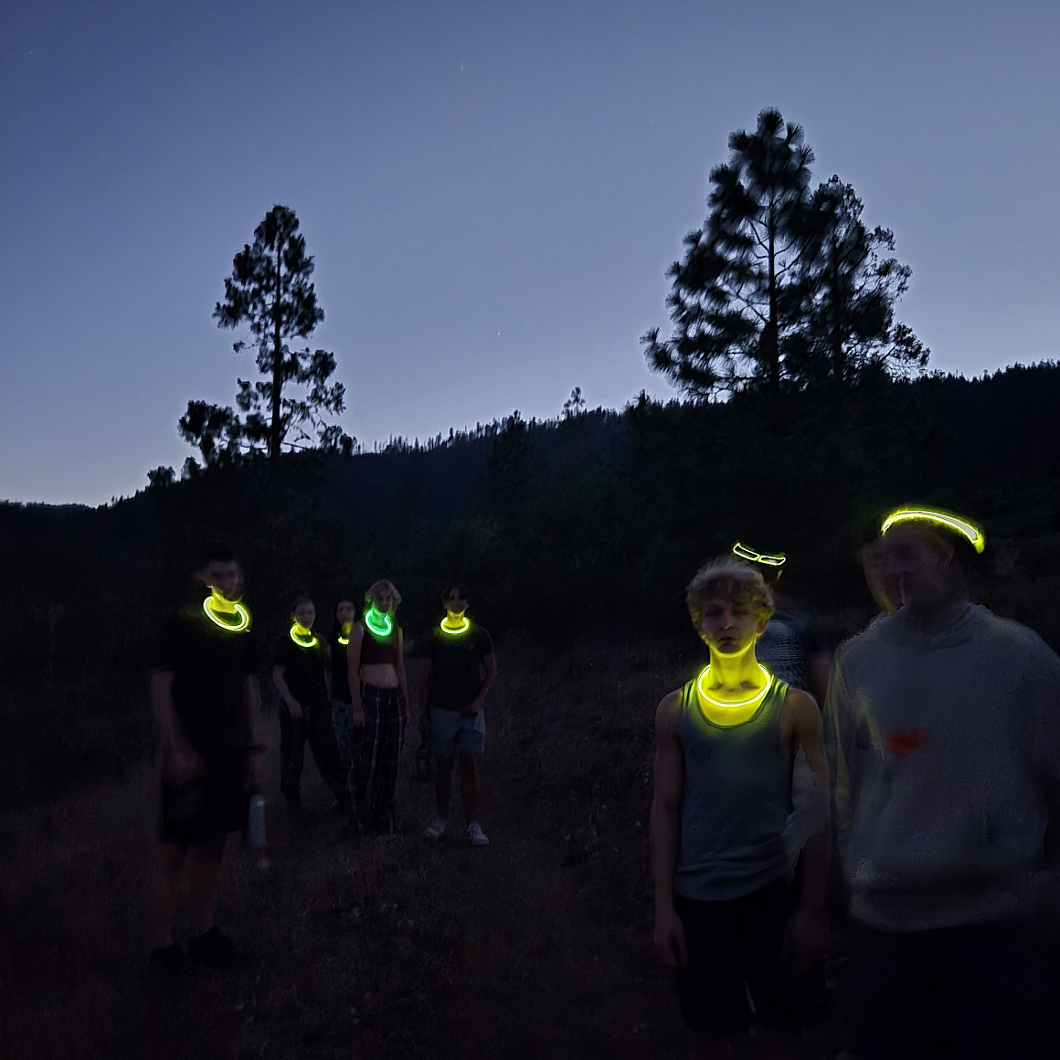 Counselors wearing glow sticks on a dark night.