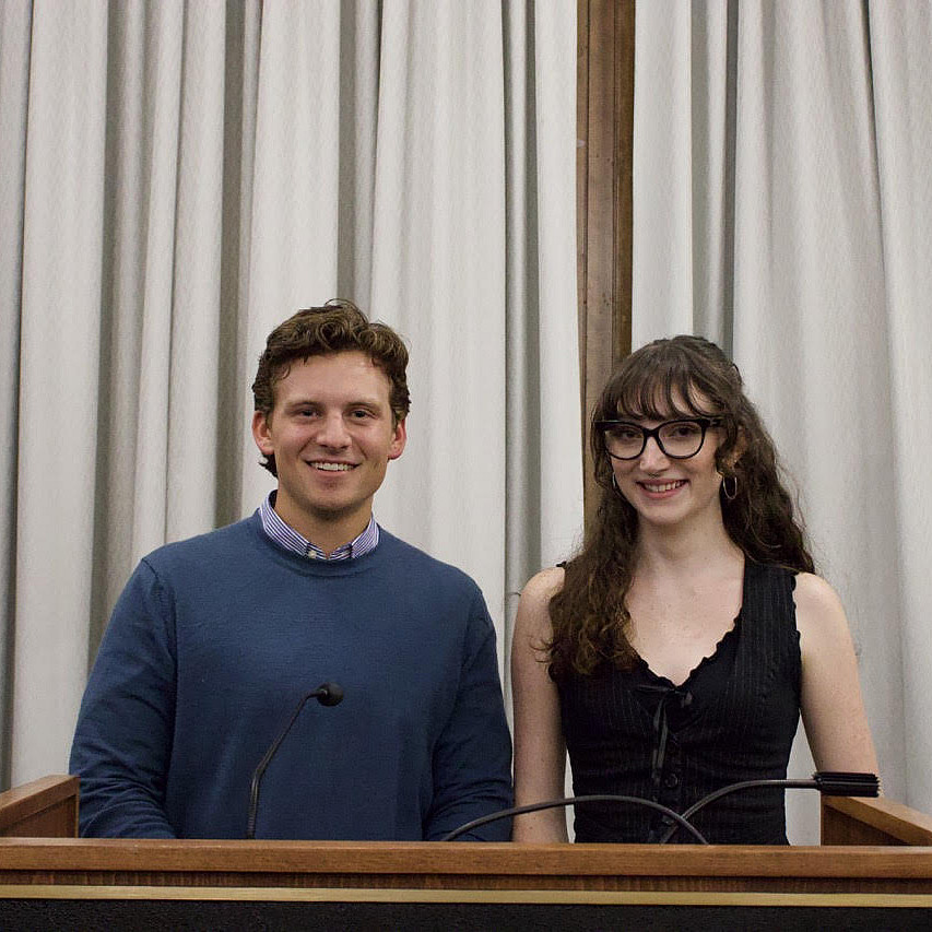 Two students stand together at a podium.