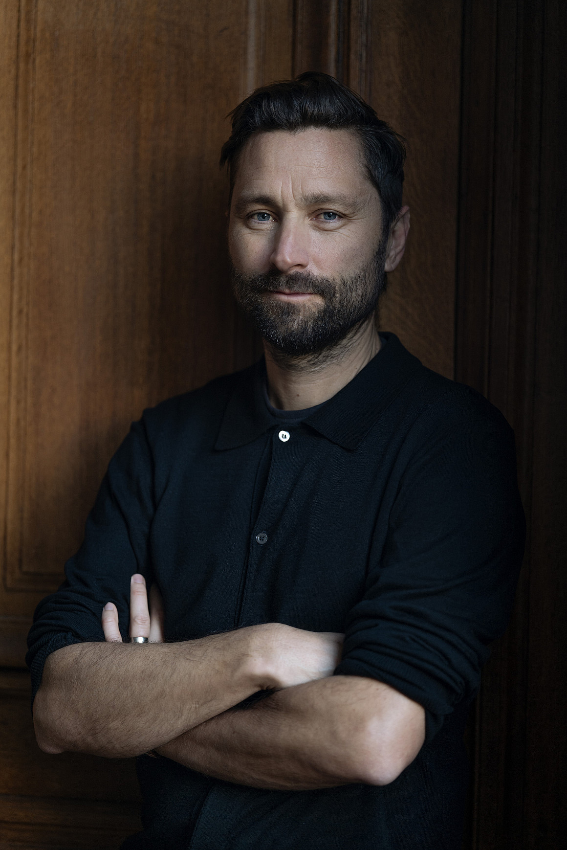 Headshot of Quinn, posing with his arms crossed.