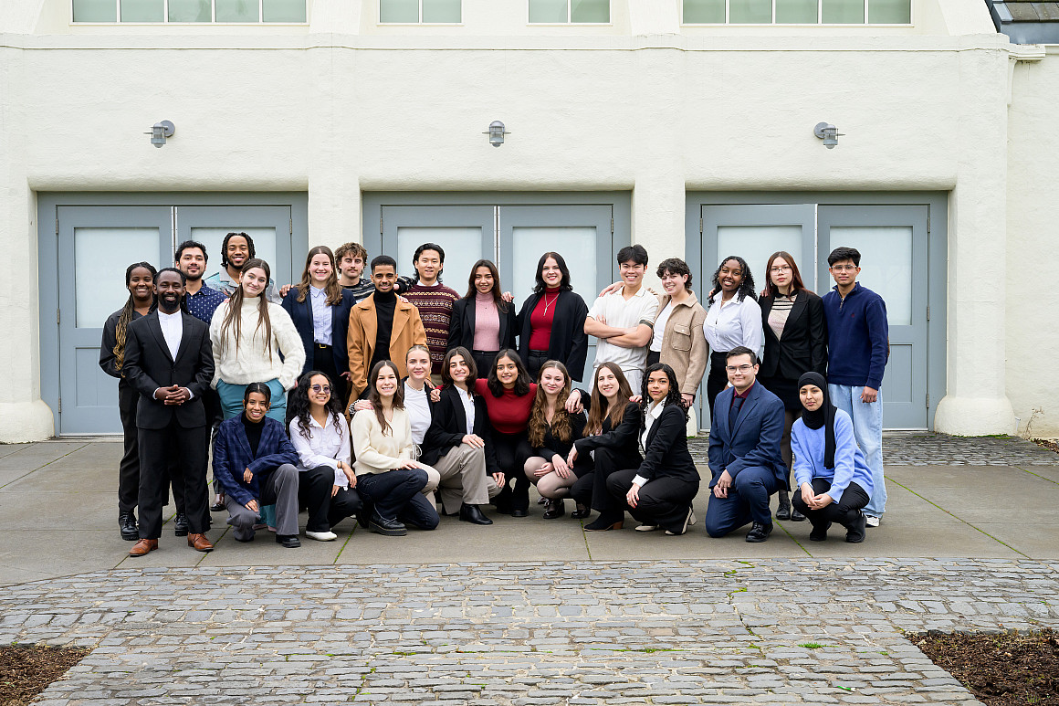 A large group of students pose together outside.