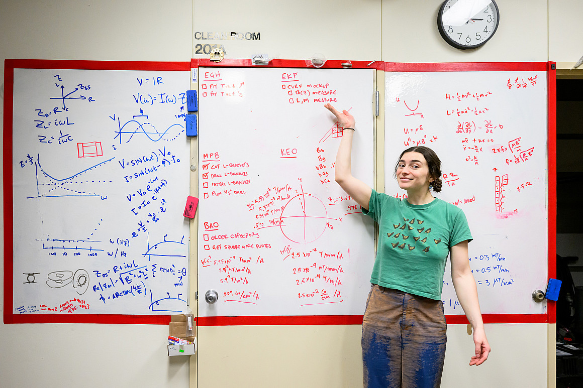 A student shows off her work on a whiteboard.