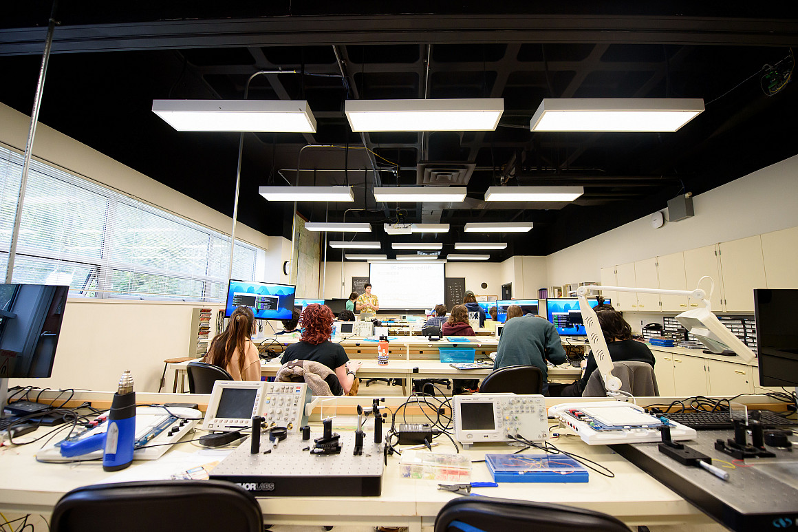 A full view of a science lab with a professor and students.