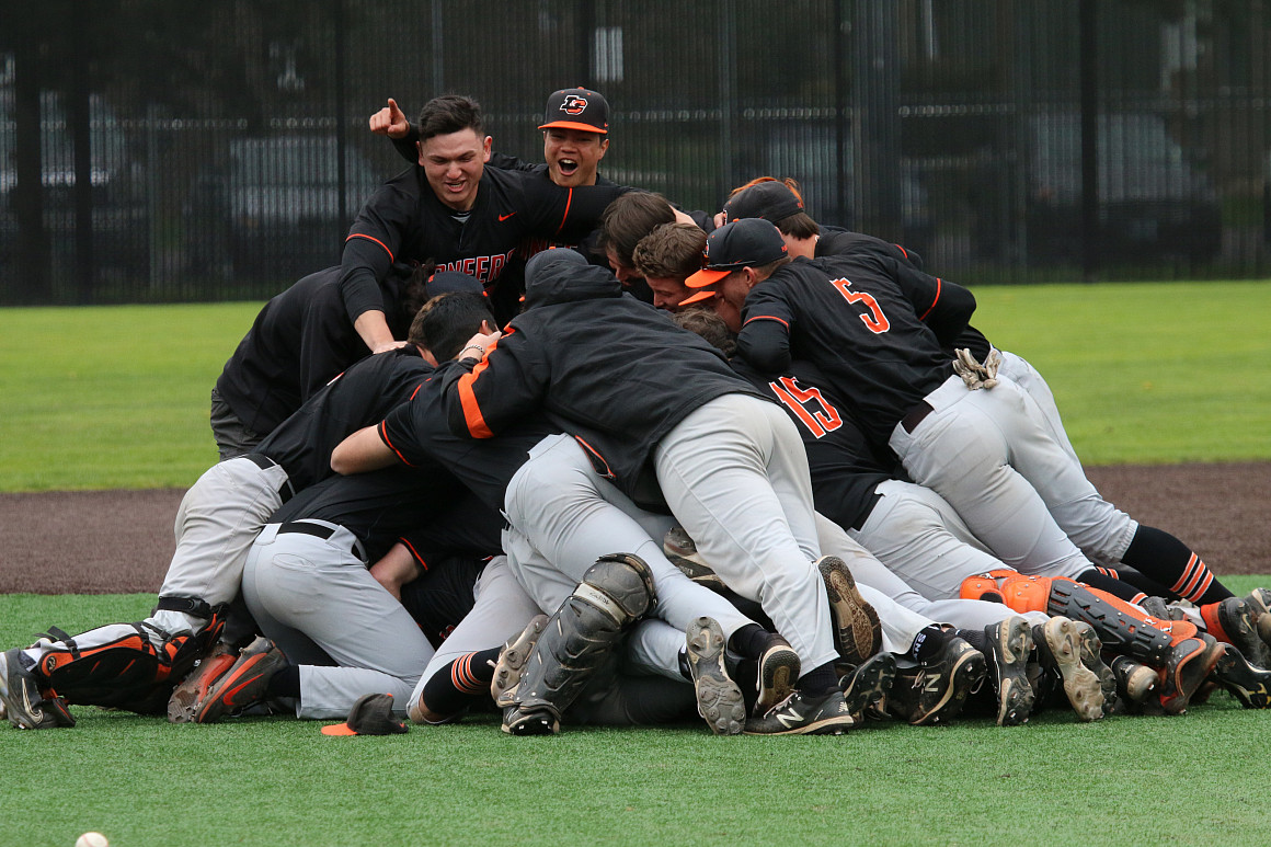Baseball team players celebrating by jumping together in giant dog pile.
