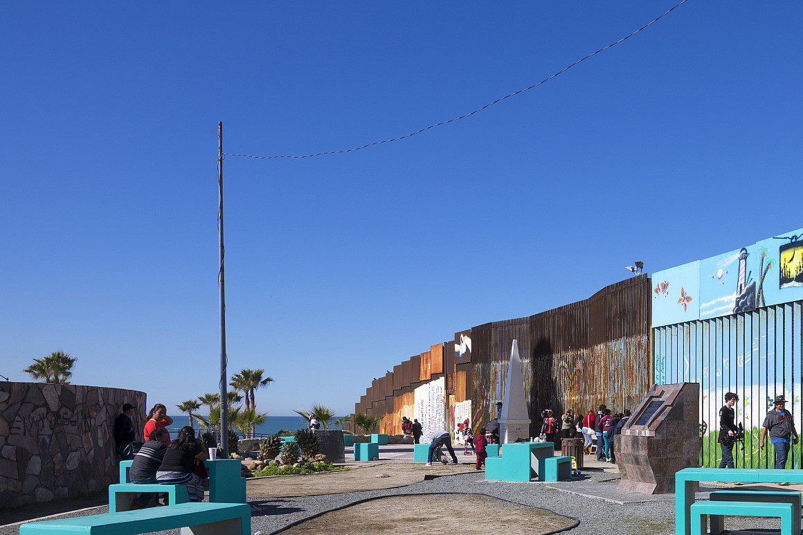 The border wall in Mexico showing a colorful mural.