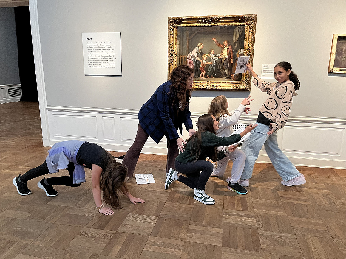 Students posing in front of a painting.