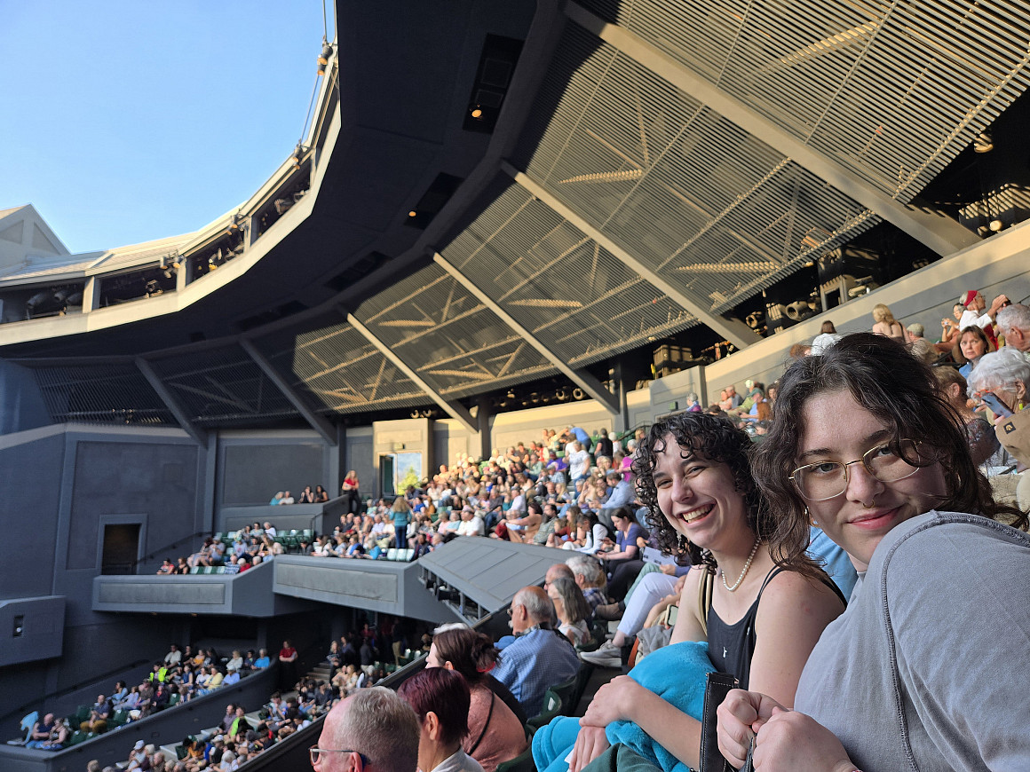 Alexandra Gische BA '25 (left) and Lila Kunkel BA '28 enjoy an outdoor performance of The Merry Wives of Windsor.