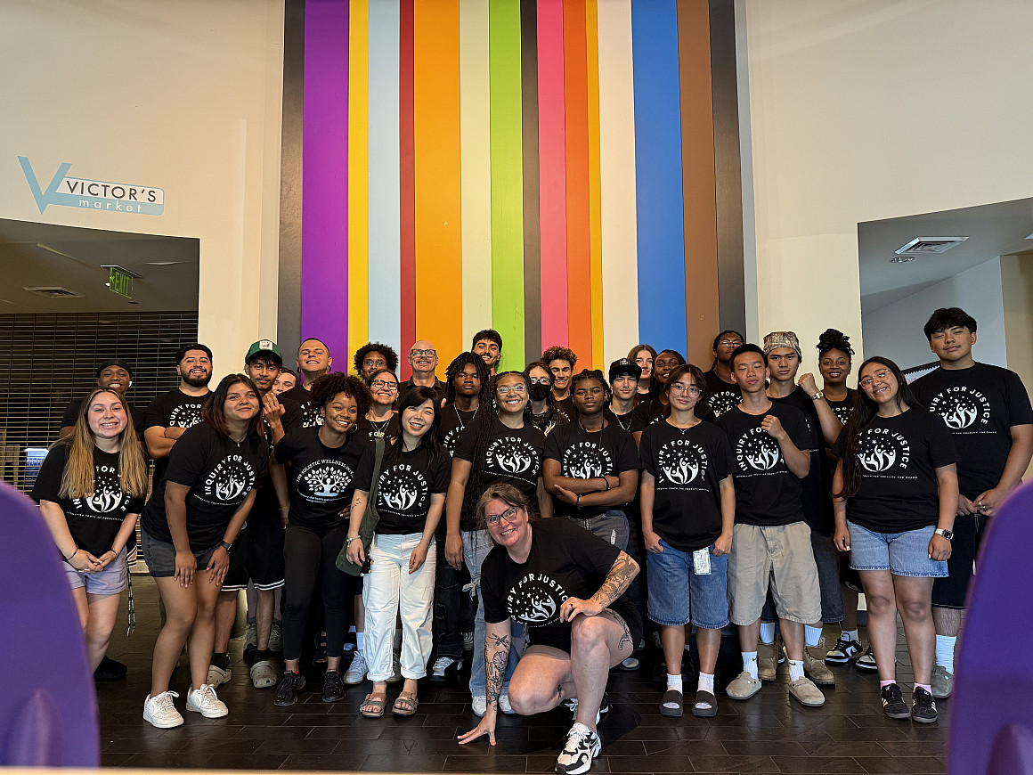 Group of people wearing matching black tshirts.