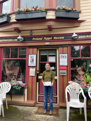 Lucy Clifford BA '24 stands outside the Portland Puppet Museum in Sellwood. This building served as Sellwood's city hall until it joined ...