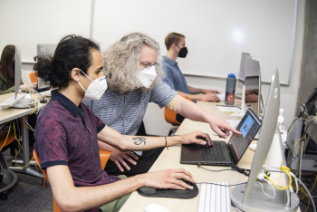 Associate Professor Peter Drake and a student researcher working on the Cascadia 9.0 earthquake preparedness game.
