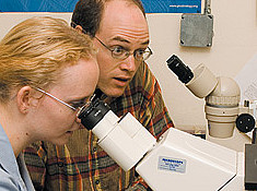 Professor of Biology Greg Hermann and Beverly Rabbitts '06 microinject a worm to alter its gene expression.