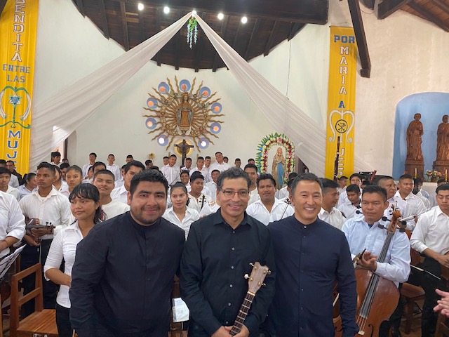 Associate Professor of Hispanic Studies Freddy Vilches and Associate Professor of Music Lance Inouye pose with the conductor of the Urubi...