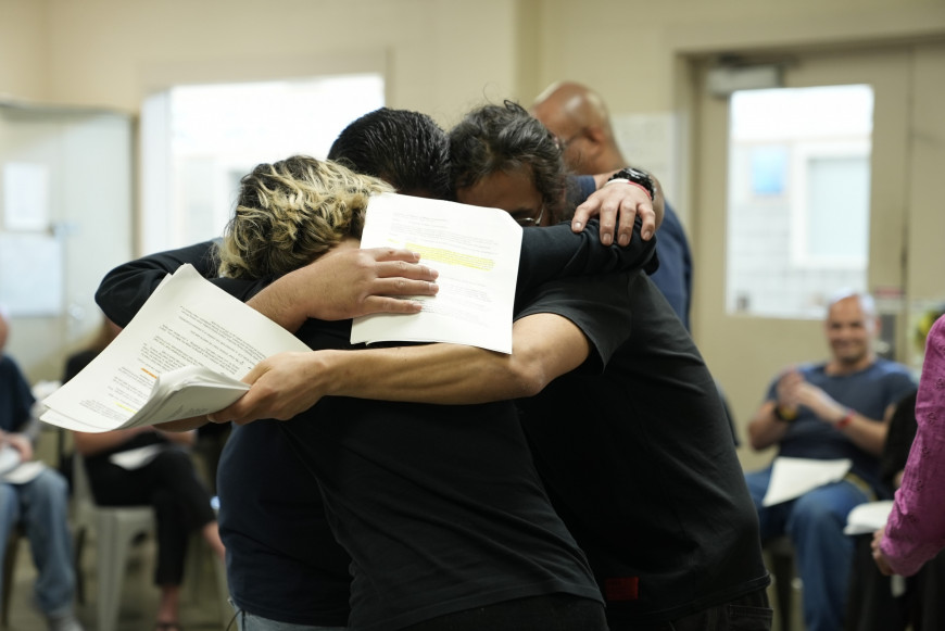 Inside and outside students hug in a group.